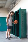 Deportista poniendo baloncesto en cabina - foto de stock