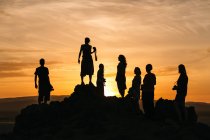 Siluetas de personas durante la puesta del sol - foto de stock
