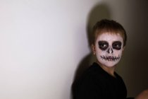 Junge mit Totenkopf-Kinderschminke schaut zur Seite — Stockfoto