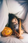 Chica maliciosa con la calabaza halloween - foto de stock