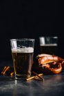 Bicchiere di birra con qualche antipasto come i pretzel — Foto stock