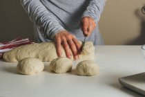 Female hands cutting dough — Stock Photo