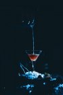 Cocktailglas auf Eiswürfeln beim Gießen — Stockfoto