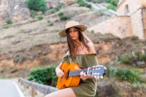 Mädchen sitzt mit Gitarre auf dem Land — Stockfoto