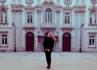 Молода жінка з рожевим волоссям в теплому одязі, що стоїть на міській вулиці . — стокове фото