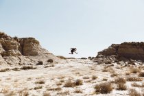 Vista laterale dell'uomo in posa in salto nel deserto — Foto stock