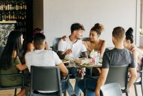 Group of friends sitting at table in restaurant and having dinner together. — Stock Photo