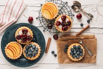 Tartlets filled with cream and fruit seen from above — Stock Photo