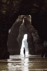Vista lejana del hombre de pie en la cueva - foto de stock