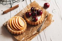 Tartlets filled with cream and fruit on rural table — Stock Photo