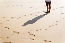 Crop homem de pé na praia de areia molhada . — Fotografia de Stock