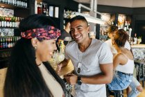 Cheerful friends drinking cocktails at bar counter — Stock Photo