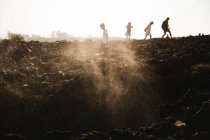 Silhouette di persone che camminano sulla scogliera — Foto stock