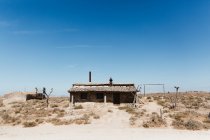 Mann sitzt auf Hüttendach in Wüstengebiet — Stockfoto
