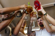 Low angle view of friends clinking cocktails in bar — Stock Photo