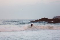 Серфер, що обертається на вершині хвилі перегону на береговій лінії — стокове фото