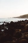Scenic landscape of rocky beach at foggy bay — Stock Photo