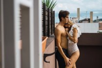 Seitenansicht eines Paares, das sich auf der Terrasse leidenschaftlich umarmt — Stockfoto
