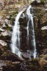 Vista panorâmica da cachoeira da montanha caindo do penhasco — Fotografia de Stock