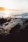 Marine panoramique de baie ensoleillée avec des falaises brumeuses et des pentes plombées — Photo de stock