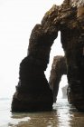 Landscape of rocky arches on sandy seashore — Stock Photo