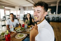 Ernte Hand geben Pommes Frites an Mann beim Essen mit Freunden im Café — Stockfoto