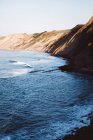 Coastal landscape with plumb shoreline and white surfing waves — Stock Photo