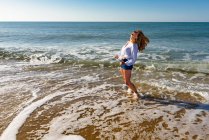 Доросла жінка стоїть на березі пляжу — стокове фото