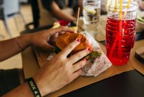 Cosecha manos femeninas recogiendo hamburguesa - foto de stock