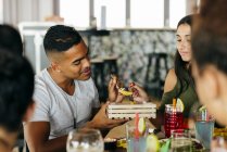 Junges Paar isst Portion Pommes, während es mit Freunden im Restaurant speist. — Stockfoto