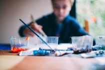 Blonde young boy painting with acrilics — Stock Photo