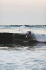 Surfer on surfboard riding foamy wave. — Stock Photo