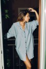 Ritratto di ragazza in camicia grigia in posa balcone foro porta — Foto stock