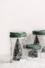 Close up view of decorative christmas trees in small glass jars — Stock Photo