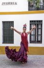 Front view of flamenco dancer wearing typical costume posing over rural building facade — Stock Photo
