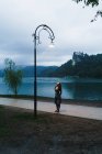 Bruna donna in piedi sul vicolo e guardando il lampione — Foto stock