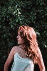 Vue latérale de la fille brune dans la lumière du soleil posant dans le jardin avec les yeux fermés — Photo de stock