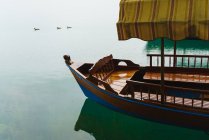 Barco vacío de cultivo con dosel de tela flotando en el lago - foto de stock