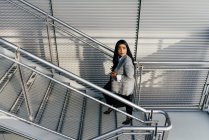 High angle view of elegant business woman walking up stairs and looking away — стоковое фото