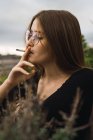 Portrait of brunette young woman smoking cigarette — Stock Photo