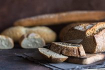 Close up view of various home-made bread on rustic table. — Stock Photo