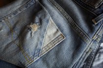 Крупный план синих джинсов, натертых карманами . — стоковое фото