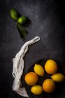 Stillleben frischer Zitronen und Orangen auf dunklem Tisch. — Stockfoto