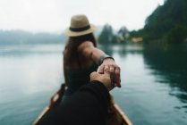 Rückansicht einer Frau mit Hut folgt mir gestikulierend auf einem Boot am See — Stockfoto