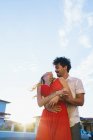 Low-Winkelaufnahme des sich umarmenden Paares, das sich an einem sonnigen Tag anschaut — Stockfoto