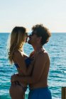 Vista laterale di abbracciare coppia amorevole sulla spiaggia — Foto stock