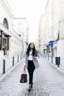 Sorrindo elegante empresária com bolsa andando na rua e olhando para longe
. — Fotografia de Stock