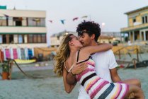 Porträt eines Mannes, der Freundin an Händen hält und sich am Strand küsst — Stockfoto
