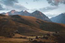 Idyllic landscape of highlands on background of pastel range of mountains. — Stock Photo