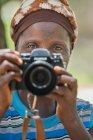 Бенін, Африка - 31 серпня 2017: Портрет етнічних жінка, стоячи і беручи вистрілив з професійним фотоапарат. — стокове фото